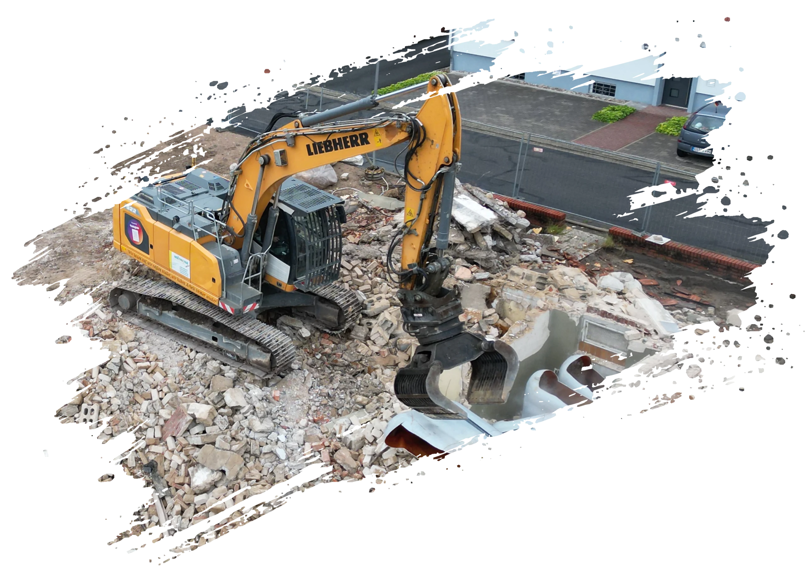 Ein gelber Liebherr-Bagger räumt Trümmer auf einer städtischen Baustelle.